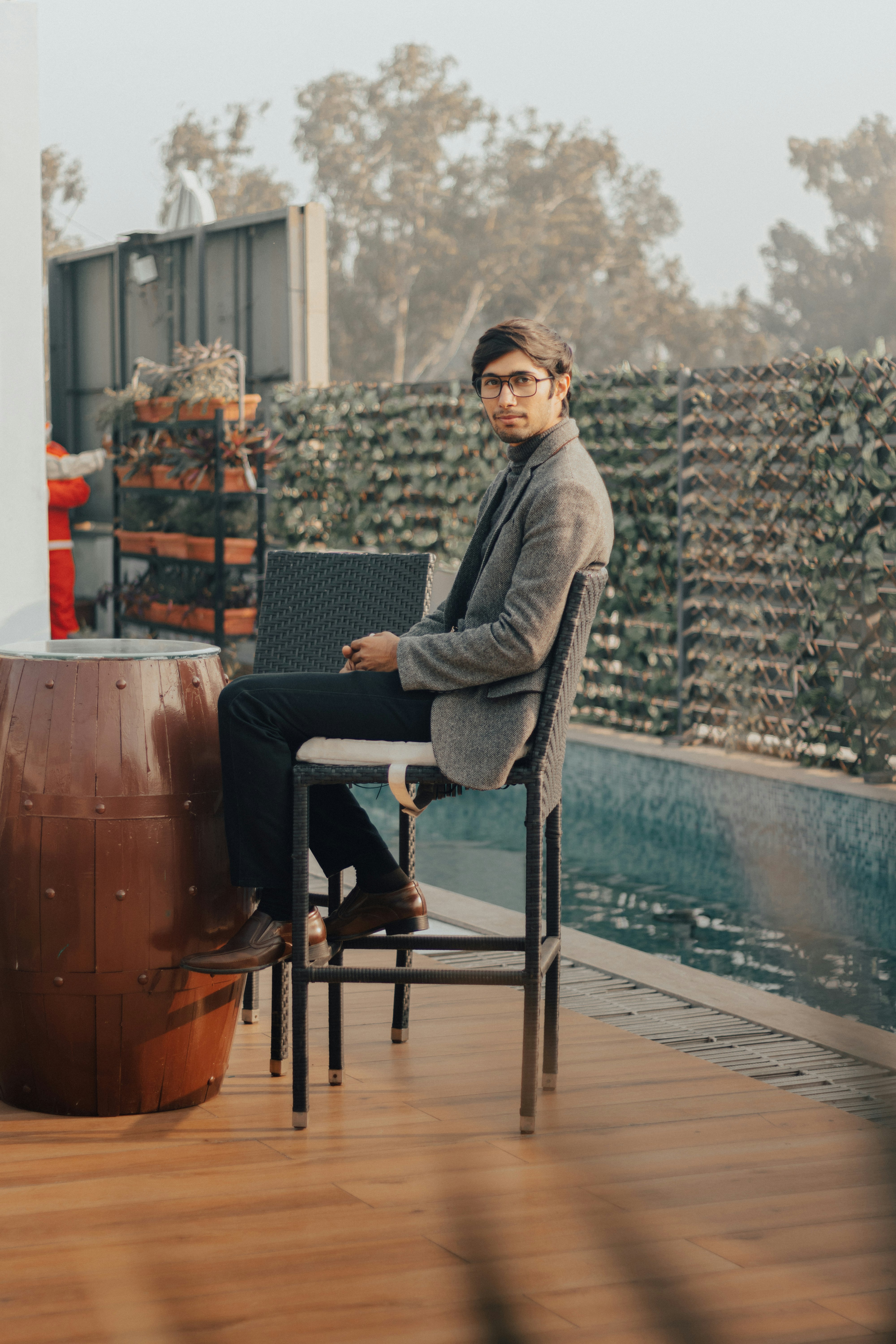 man in gray blazer sitting on black armchair